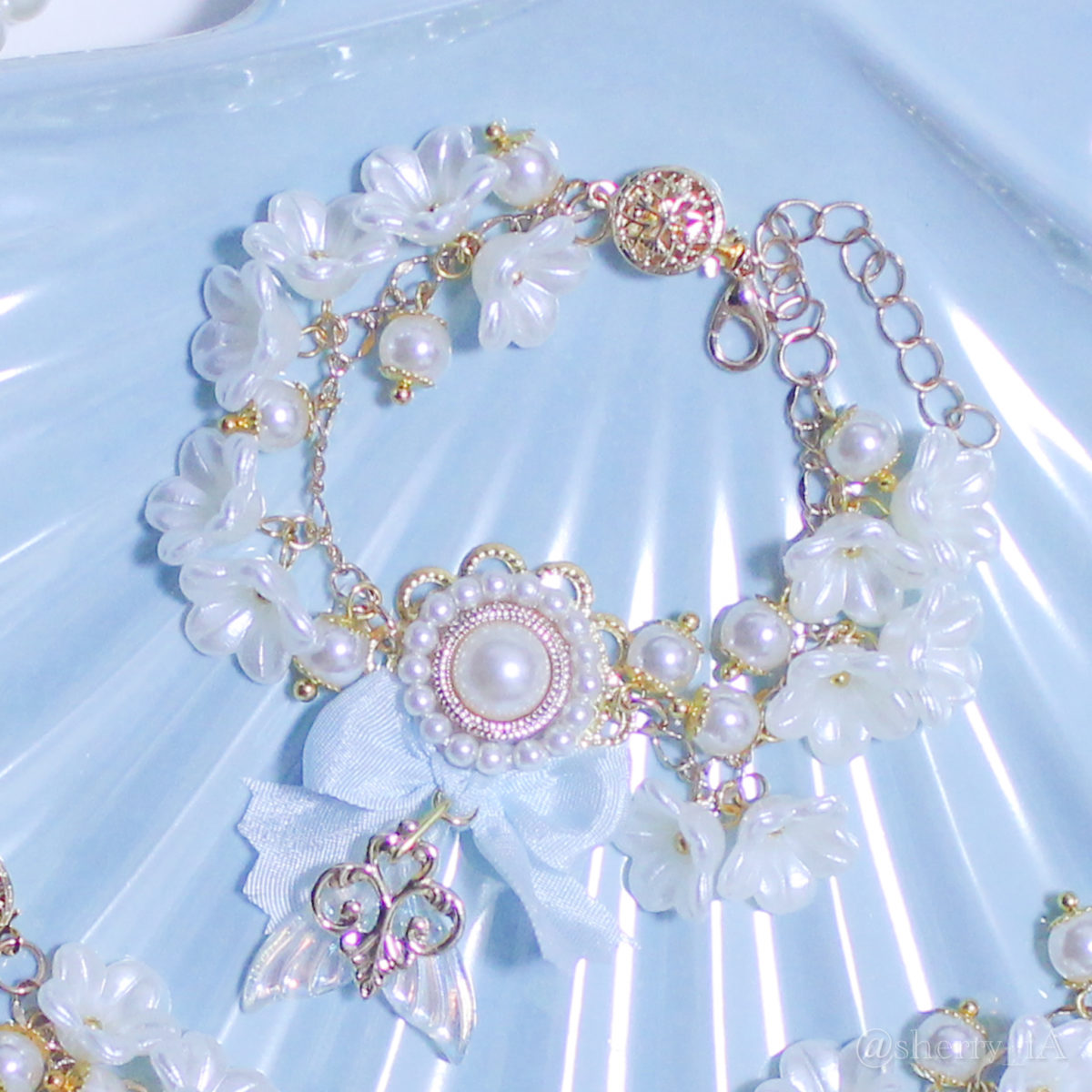 アミュリボン 華やかな白百合の花冠をかぶる人魚姫のブレスレット パールとお花のパールをたくさん使って作ったマーメイドモチーフのハンドメイドアクセサリー 淡い水色