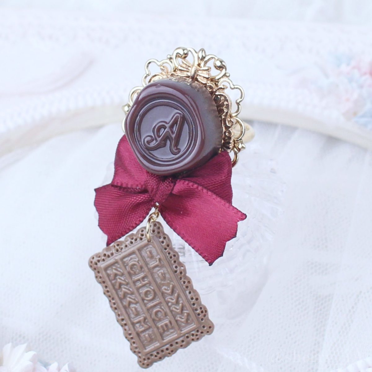 アミュリボン ロマンスチョコリング クラシカル ボルドー シーリングスタンプモチーフのチョコレートにリボンとチョコで作ったハンドメイドアクセサリー