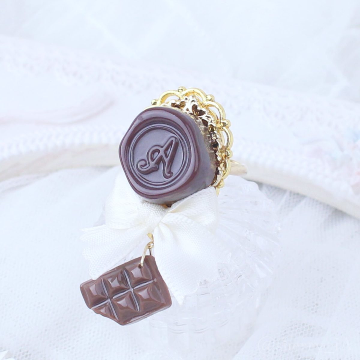 アミュリボン ロマンスチョコリング シーリングスタンプモチーフのチョコレートにリボンとチョコで作ったハンドメイドアクセサリー クリームホワイト