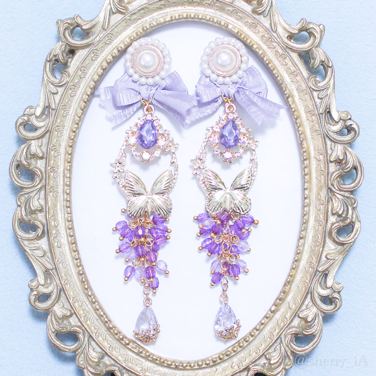 アミュリボン 華やかな香り纏う豊穣の葡萄 耳飾り ビジューと小さなビーズをたくさん使い繊細に作り上げた藤のようにしだれる葡萄と蝶のハンドメイドアクセサリー ピアス/イヤリング 藤色